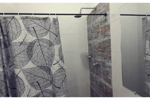 a shower with a black and white shower curtain at Villa Aurora in Ricaurte