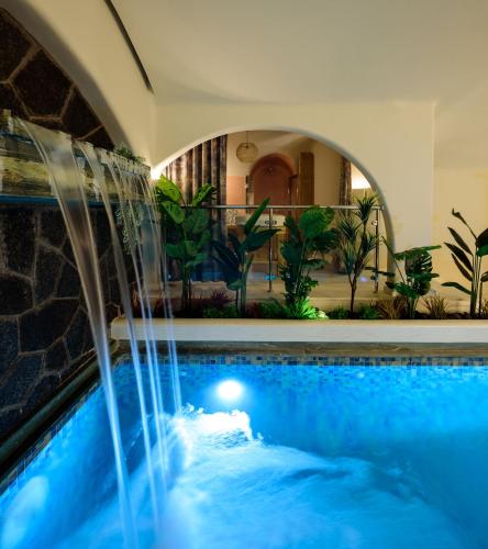 a swimming pool with a fountain in a hotel room at Acro Blue Luxury Villas in Akrotiri