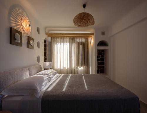 a bedroom with a large bed and a window at Acro Blue Luxury Villas in Akrotiri