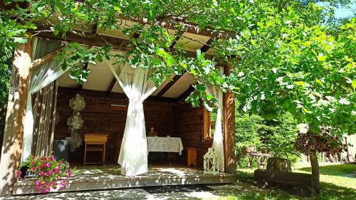 une cabane en bois avec une arche de mariage dans la cour dans l'établissement Veski Aida Holiday Home, à Käina