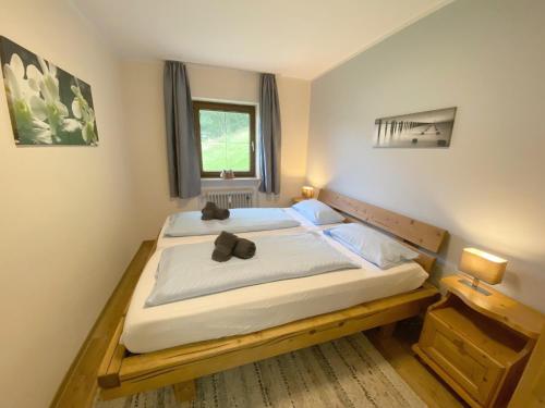 um quarto com uma cama grande com um laço em Ferienwohnung 5 Bergschlössl Oberaudorf em Oberaudorf