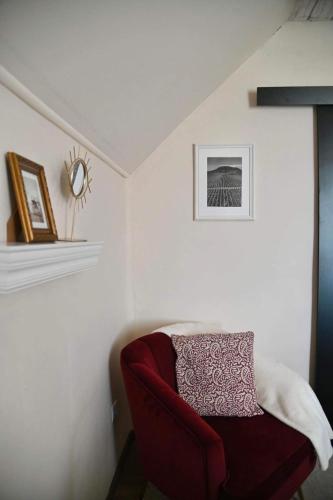 a red chair sitting in a corner of a room at Rubin in Doba