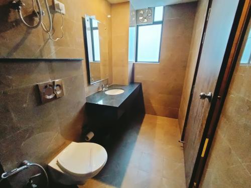 a bathroom with a toilet and a sink and a mirror at Mayda Inn- A Boutique Hotel in New Delhi