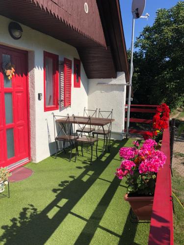 a house with a red door and a table and flowers at Rubin in Doba