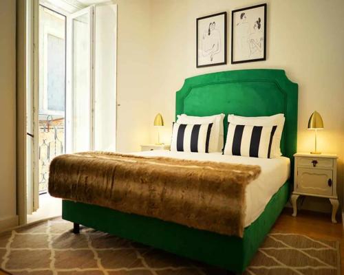 een slaapkamer met een groen bed en een raam bij Vila Intendente - Apartamento 2 Quartos in Lissabon