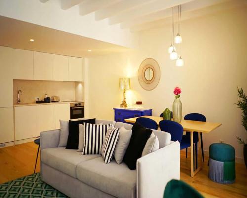 a living room with a couch and a table and a kitchen at Vila Intendente - Apartamento 2 Quartos in Lisbon