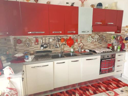 庫佩洛的住宿－Casa Vacanze e B&B In Piazza，厨房配有白色的柜台和红色的橱柜