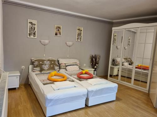 een slaapkamer met een wit bed en een grote spiegel bij Magic Garten in Hévíz