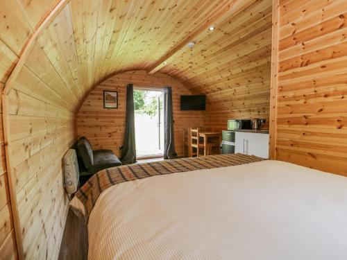 a bedroom with a bed in a wooden cabin at Pod 1 in Seascale