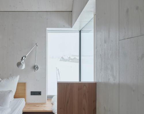 a bedroom with a bed and a large window at Urban Alpine Penthouse with Lake View in Maurach