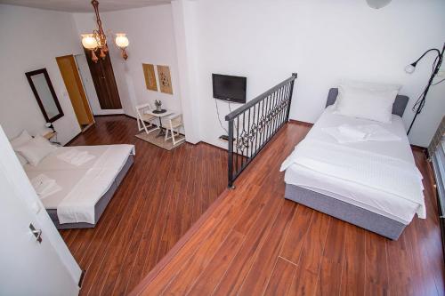 a room with two beds and a table and a television at Miro apartments in Mostar