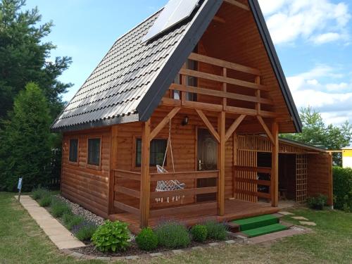 a large wooden cabin with a gambrel roof at Domek Letniskowy "Domek Lawendowy" in Pisz