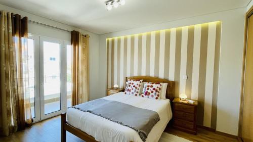 a bedroom with a bed and a large window at Alice by Check-in Portugal in Albufeira