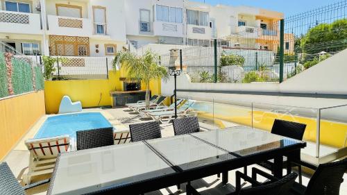 a balcony with a table and chairs and a swimming pool at Alice by Check-in Portugal in Albufeira