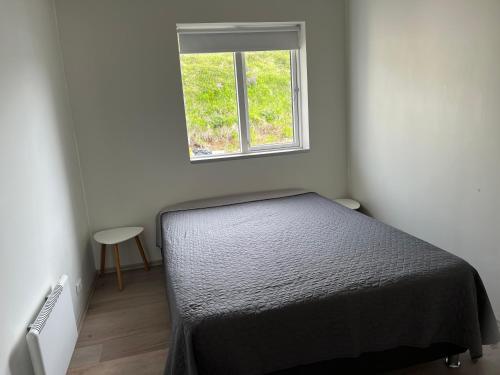 1 dormitorio con cama y ventana en Akureyri - cabin with an amazing view, en Akureyri