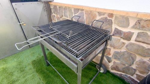 a grill sitting next to a stone wall at Escapada Delux in Ossa de Montiel