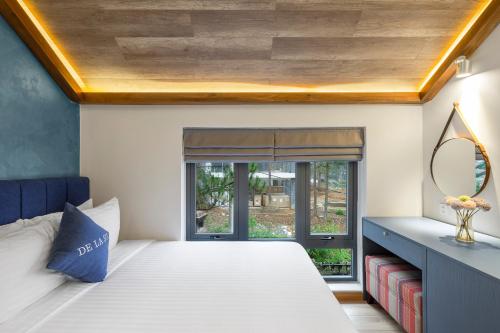 a bedroom with a large bed and a window at De La Sol Villa Dalat in Da Lat