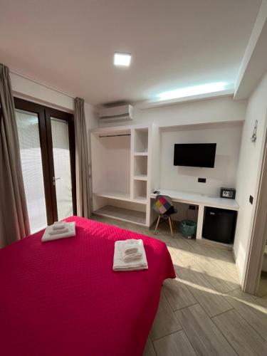 a bedroom with a red bed and a tv at Residenza Azzurra in Tropea