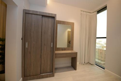 bagno con cabina in legno e specchio di WDF Serviecd Apartment a Gedda