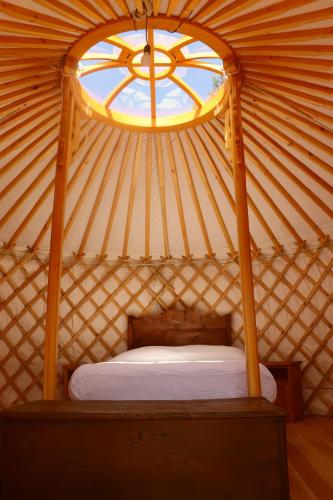 a room with a bed in a yurt with a window at Glamping la Cascina d'Orleans in Saint-Pierre