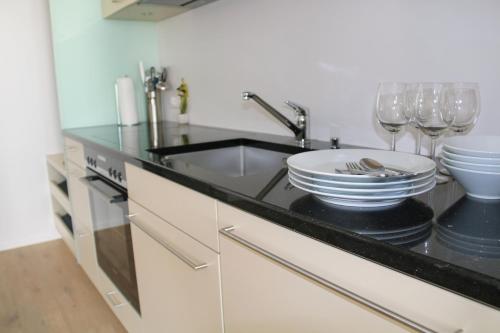 a kitchen counter with wine glasses and a sink at Hotel Sonne Interlaken-Matten in Interlaken