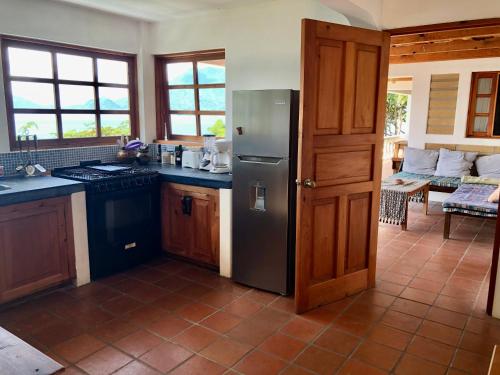 a kitchen with a stainless steel refrigerator in a room at Rustic Charm and Breathtaking Views in Santa Cruz La Laguna