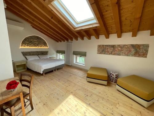 - une grande chambre avec un lit et une lucarne dans l'établissement Agriturismo ValBarè, à Fregona