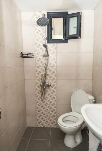 a bathroom with a shower with a toilet and a sink at Еко Къщи Къмпинг Созопол Еко in Sozopol