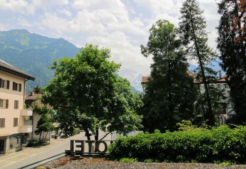a street with trees and a bench in a town at Hotel Sonne Interlaken-Matten in Interlaken