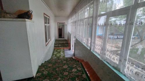 a hallway of a house with windows and a rug at Panorama in Arslanbob