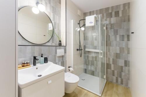 W łazience znajduje się toaleta, umywalka i lustro. w obiekcie Klif Apartamenty Polanki Aqua A414 w Kołobrzegu