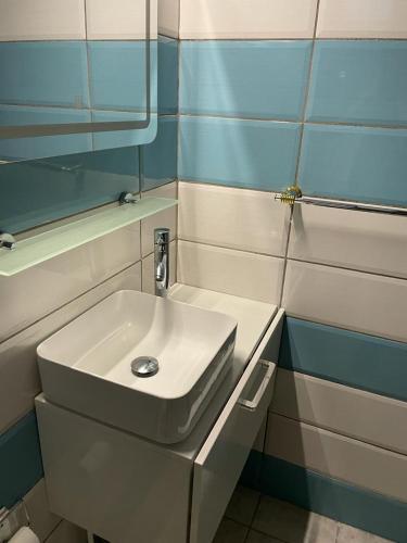 La salle de bains est pourvue d'un lavabo blanc et d'un miroir. dans l'établissement Verveine, à Vieux Bourg