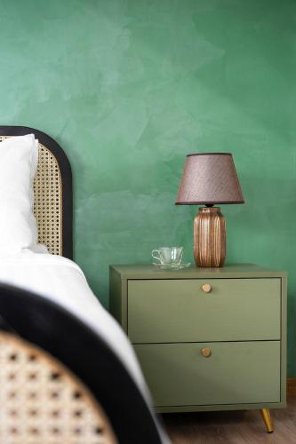 a lamp on a dresser next to a bed at De La Sol Villa Dalat in Da Lat