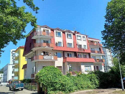 a tall apartment building with a sign on it at Komfortowy pokój gościnny 300 m od morza dzielnica uzdrowisk in Kołobrzeg