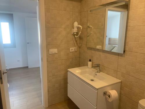 a bathroom with a sink and a mirror at Apartamentos Villa Pirata Tarifa in Tarifa