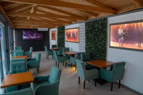 a waiting room with tables and green chairs at Holiday Park Verse in Ulcinj