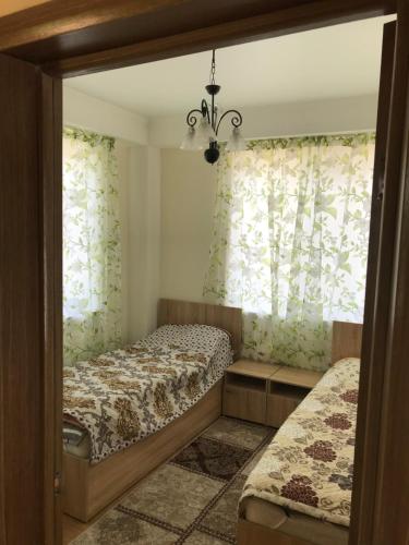 a small bedroom with two beds and curtains at Берег in Bosteri