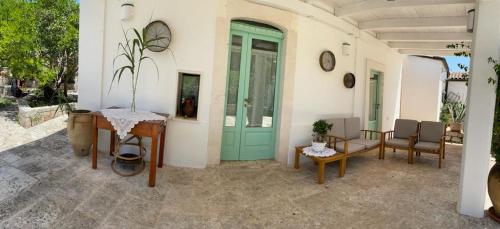 チェーリエ・メッサーピカにあるIl Giardino degli Antichi Saporiの緑のドアとテーブルと椅子が備わる家