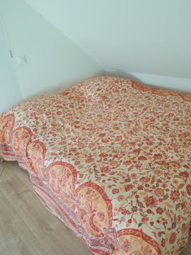 オクセル・オーにあるStudio calme et lumineux avec terrasseの花の毛布が敷かれたベッド