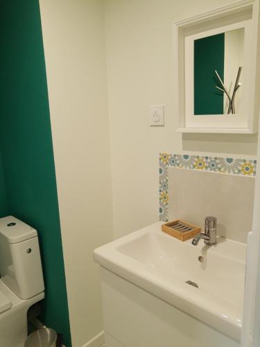 a bathroom with a white sink and a toilet at Studio calme et lumineux avec terrasse in Auxelles-Haut