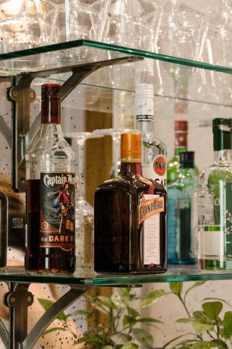 two bottles of alcohol sitting on a glass shelf at The Adria in London
