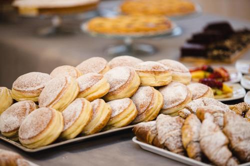 a bunch of donuts and other pastries on trays at Hotel Lydia in Cervia