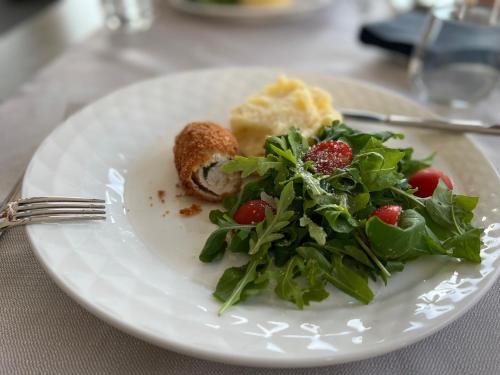 a plate of food with a salad on a table at Hotel Millenium deluxe in Selce