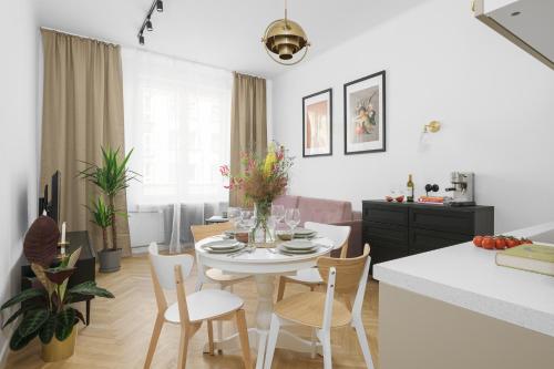 a kitchen and living room with a white table and chairs at oompH Warsaw Central Stylish Vintage Apartment in Warsaw