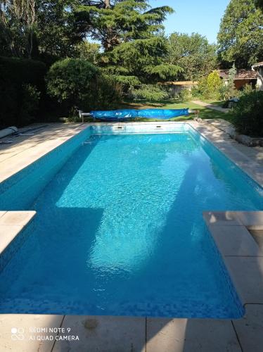 l'Annexe, logement confortable avec piscine في مازان: مسبح بمياه زرقاء في ساحة