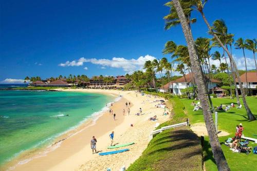 a group of people on a beach near the ocean at Oceanview 1BR at Kiahuna Plantation Unit 159 in Koloa