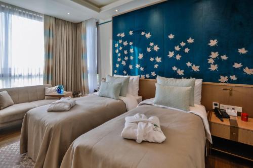 a hotel room with two beds and a couch at Dreamland Golf Hotel Baku in Baku