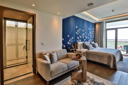 a bedroom with a bed and a couch at Dreamland Golf Hotel Baku in Baku