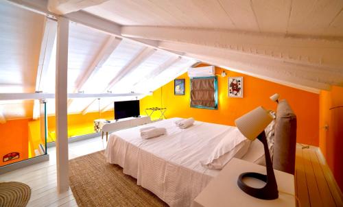 a bedroom with a white bed and a yellow wall at Villa Kirki Apartments in Agia Effimia
