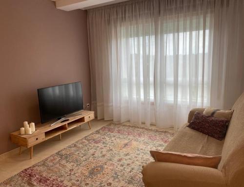 uma sala de estar com um sofá e uma televisão de ecrã plano em Tu hogar en el corazón de O Salnés em Meaño